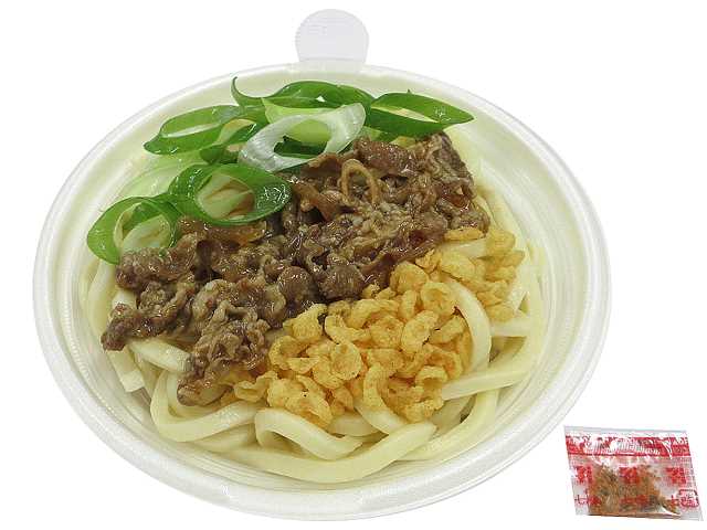 セブンイレブンの牛の旨み広がる肉うどんを比較する。税込価格：572円、カロリー：526kcal、1円あたりカロリー：0.92kcal/円、たんぱく質：14.5g、1円あたりたんぱく質：0.03g/円、脂質：21g、炭水化物：71.9g、糖質：67.4g、食物繊維：4.5g、食塩相当量：4.9g。牛肉煮を盛付けた温かいうどんです。アレルギー：小麦、えび。