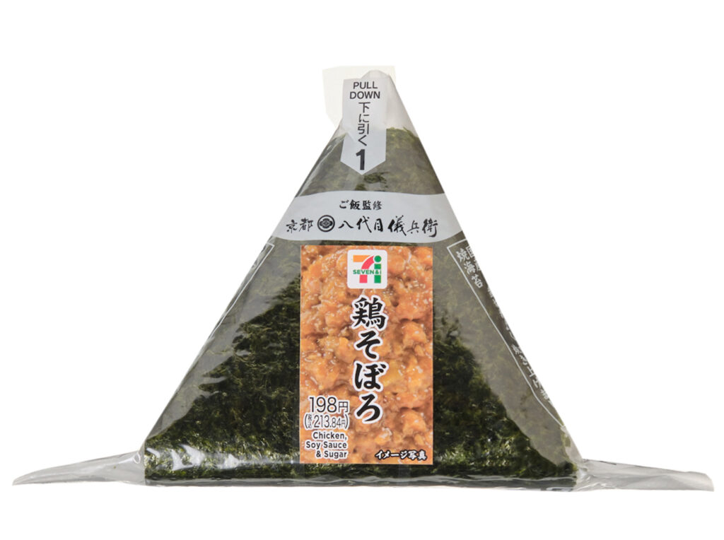 セブンイレブンの手巻おにぎり 鶏そぼろを比較する。税込価格：214円、カロリー：199kcal、1円あたりカロリー：0.93kcal/円、たんぱく質：5.5g、1円あたりたんぱく質：0.03g/円、脂質：2.8g、炭水化物：38.8g、糖質：36.9g、食物繊維：1.9g、食塩相当量：1.3g。醤油と砂糖で甘辛く味付けし、生姜をきかせて後味すっきりに仕上げた鶏そぼろを中具にしました。食べる直前にパリッとした海苔を巻いて食べる手巻おにぎりです。アレルギー：小麦。