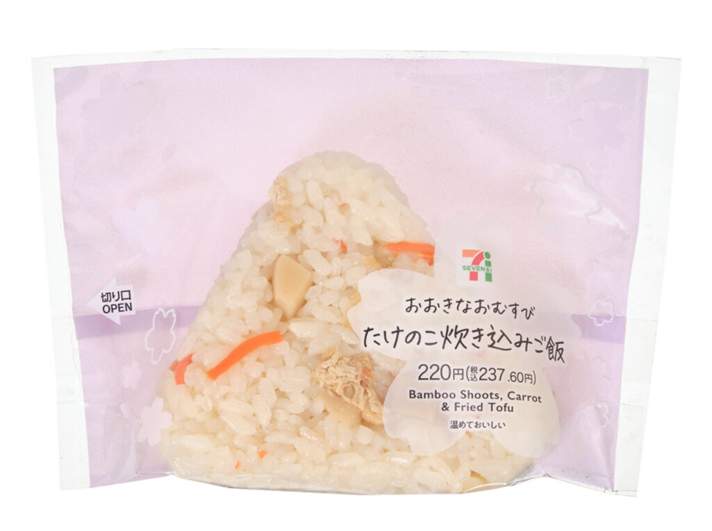 セブンイレブンのおおきなおむすび たけのこ炊き込みご飯を比較する。税込価格：238円、カロリー：252kcal、1円あたりカロリー：1.06kcal/円、たんぱく質：4.6g、1円あたりたんぱく質：0.02g/円、脂質：1.8g、炭水化物：55.6g、糖質：53.1g、食物繊維：2.5g、食塩相当量：2.5g。春の味覚であるたけのこを使用した、炊き込みご飯のおむすびです。アレルギー：小麦。
