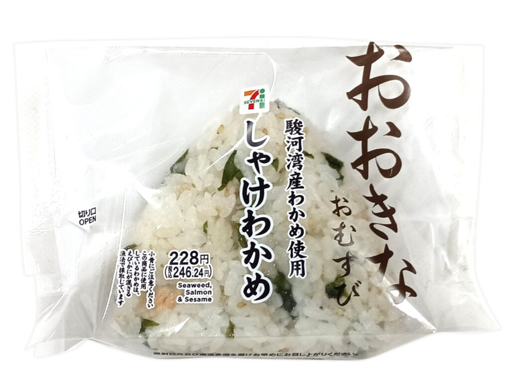 セブンイレブンのおおきなおむすびしゃけわかめを比較する。税込価格：246円、カロリー：250kcal、1円あたりカロリー：1.02kcal/円、たんぱく質：5.6g、1円あたりたんぱく質：0.02g/円、脂質：2.1g、炭水化物：53.3g、糖質：50.8g、食物繊維：2.5g、食塩相当量：2.6g。だしで炊いたご飯に、駿河湾産わかめとほぐしたしゃけを混ぜ込んだおむすびです。アレルギー：なし。