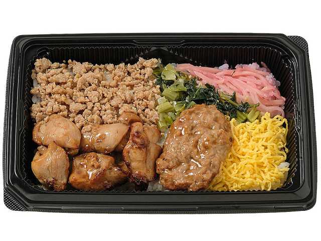 セブンイレブンの焼き鳥と鶏つくね重を比較する。税込価格：700円、カロリー：651kcal、1円あたりカロリー：0.93kcal/円、たんぱく質：24.2g、1円あたりたんぱく質：0.03g/円、脂質：21.8g、炭水化物：91g、糖質：87.9g、食物繊維：3.1g、食塩相当量：2.8g。ご飯の上に、焼き鳥，鶏つくね，鶏そぼろ，小松菜の炒め煮，錦糸玉子，紅生姜を盛り付けたお弁当です。アレルギー：卵、小麦。