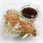 セブンイレブンの新玉ねぎサラダを比較する。税込価格：246円、カロリー：51kcal、1円あたりカロリー：0.21kcal/円、たんぱく質：2.4g、1円あたりたんぱく質：0.01g/円、脂質：0.4g、炭水化物：10.3g、糖質：8.5g、食物繊維：1.8g、食塩相当量：1.7g。広島県因島産の新玉ねぎを使用したサラダです。和風だしの効いたポン酢と鰹節で旨味のある味わいです。アレルギー：小麦。