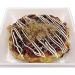 セブンイレブンの鉄板焼き お好み焼き（ぶた玉）を比較する。税込価格：551円、カロリー：463kcal、1円あたりカロリー：0.84kcal/円、たんぱく質：13.4g、1円あたりたんぱく質：0.02g/円、脂質：27.3g、炭水化物：43g、糖質：38.9g、食物繊維：4.1g、食塩相当量：3.9g。鉄板で１枚１枚、丁寧に焼き上げたお好み焼きです。アレルギー：卵、乳、小麦。