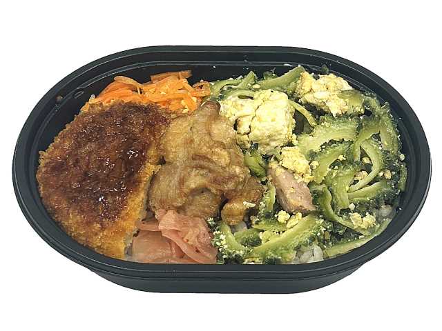 セブンイレブンのゴーヤーチャンプルー弁当もち麦入り。税込価格：430円、カロリー：399kcal、たんぱく質：13.9g、脂質：11.3g、炭水化物：62.9g、糖質：58.1g、食物繊維：4.8g、食塩相当量：2.1g。もち麦入りのごはんと、沖縄で定番のゴーヤーチャンプルーと人参しりしり，コロッケや唐揚げを詰め合わせた満足感のあるミニサイズのお弁当です。アレルギー：卵、乳、小麦。