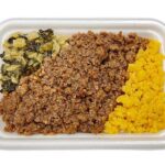 セブンイレブンの鶏そぼろごはん（麦飯）。税込価格：430円、カロリー：366kcal、たんぱく質：13.5g、脂質：6.4g、炭水化物：65g、糖質：62.3g、食物繊維：2.7g、食塩相当量：2.2g。麦飯に、しっとりとした優しい味わいの鶏そぼろ煮に玉子そぼろと高菜炒め煮を盛り付けた御飯です。アレルギー：卵、小麦。