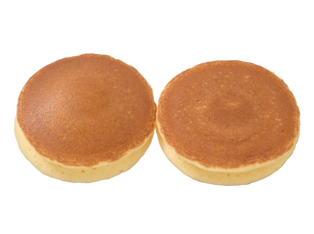 セブンイレブンの７Ｐ しっとりホットケーキ北海道つぶあん＆ホイップ２個入。税込価格：160円、カロリー：209kcal、たんぱく質：3.6g、脂質：4.4g、炭水化物：39.2g、糖質：38.2g、食物繊維：1g、食塩相当量：0.4g。生クリームを使用したしっとり食感のホットケーキ生地に、北海道産小豆のつぶあんとミルクホイップクリームをサンドしました。アレルギー：卵、乳、小麦。