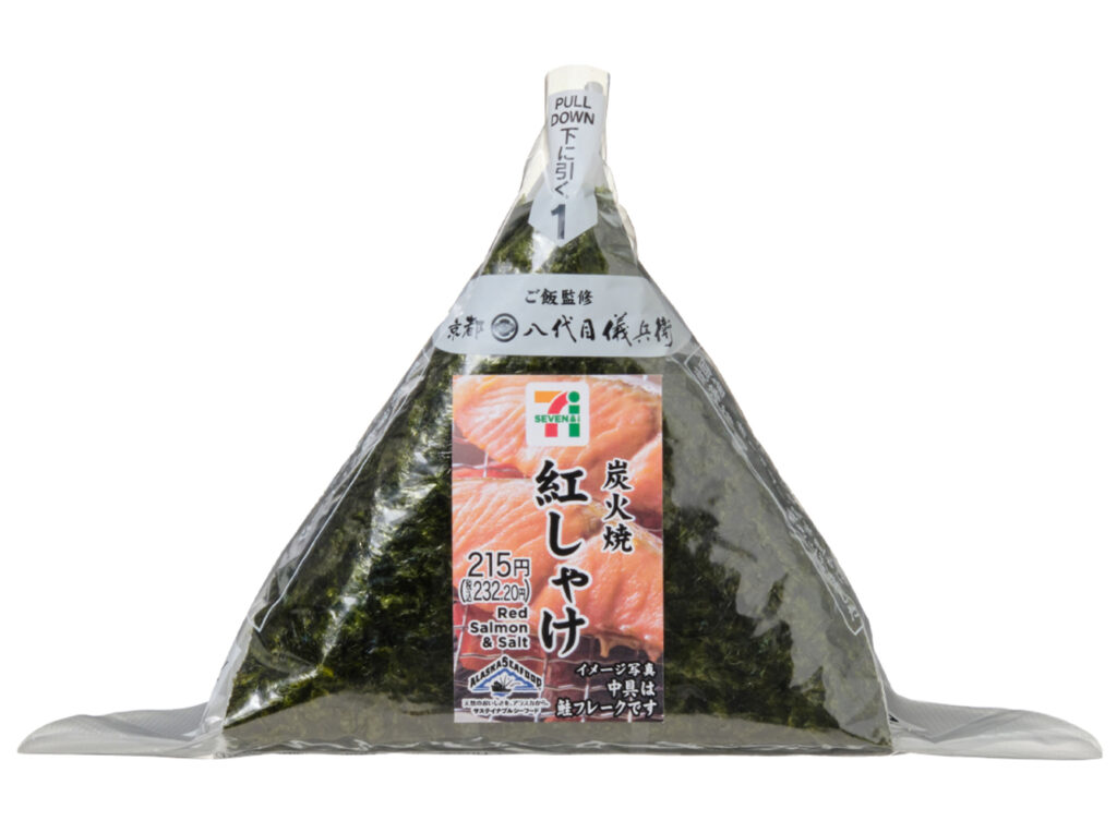 セブンイレブンの手巻おにぎり 炭火焼紅しゃけを比較する。税込価格：232円、カロリー：174kcal、1円あたりカロリー：0.75kcal/円、たんぱく質：4.6g、1円あたりたんぱく質：0.02g/円、脂質：1.8g、炭水化物：35.9g、糖質：34g、食物繊維：1.9g、食塩相当量：0.9g。炭火で香ばしく焼き上げた紅しゃけを中具にした、パリッとした海苔を巻いて食べる手巻おにぎりです。アレルギー：なし。
