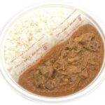 セブンイレブンのまんぷくポークカレーを比較する。税込価格：646円、カロリー：729kcal、1円あたりカロリー：1.13kcal/円、たんぱく質：19.3g、1円あたりたんぱく質：0.03g/円、脂質：20.8g、炭水化物：120.8g、糖質：111.4g、食物繊維：9.4g、食塩相当量：4.6g。お肉の旨味や野菜と果実の甘味が溶け込んだ食べ応えのあるポークカレーです。アレルギー：乳、小麦。