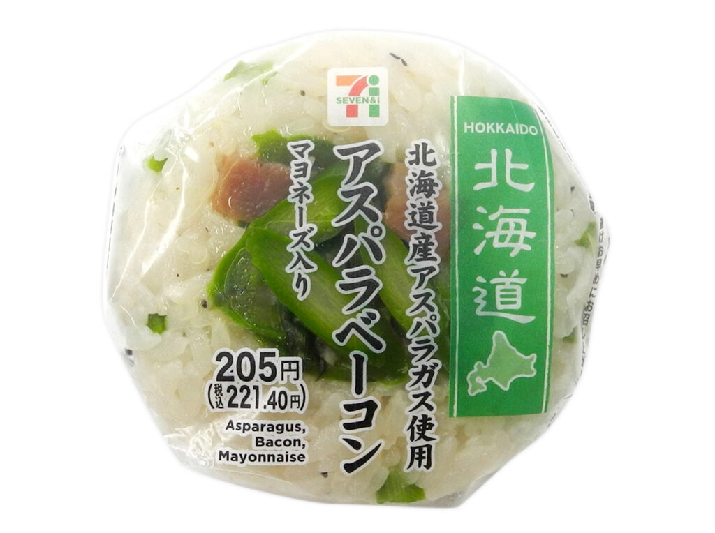 セブンイレブンのアスパラベーコンおむすびを比較する。税込価格：221円、カロリー：199kcal、1円あたりカロリー：0.90kcal/円、たんぱく質：3.6g、1円あたりたんぱく質：0.02g/円、脂質：4.2g、炭水化物：37.6g、糖質：35.9g、食物繊維：1.7g、食塩相当量：1.4g。旬のアスパラガスを混ぜ込んだ胡椒御飯の上にベーコンと組み合わせたアスパラガスを乗せ、間にペッパーマヨネーズを挟んで食べ進み良く仕上げました。アレルギー：卵、乳、小麦。
