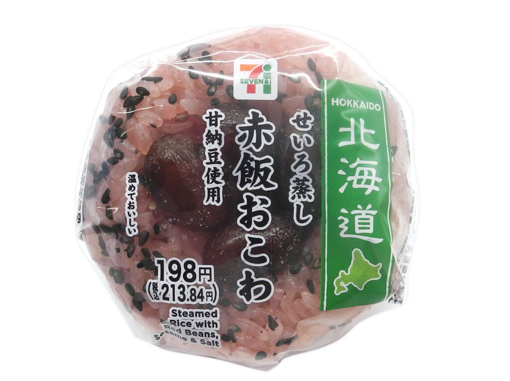 セブンイレブンのせいろ蒸し赤飯おこわ おむすびを比較する。税込価格：214円、カロリー：240kcal、1円あたりカロリー：1.12kcal/円、たんぱく質：4.5g、1円あたりたんぱく質：0.02g/円、脂質：1.5g、炭水化物：52.6g、糖質：51.4g、食物繊維：1.2g、食塩相当量：0.6g。せいろで蒸したもちもち食感の赤飯おこわに、北海道で馴染みのある甘納豆を乗せたおむすびです。アレルギー：なし。