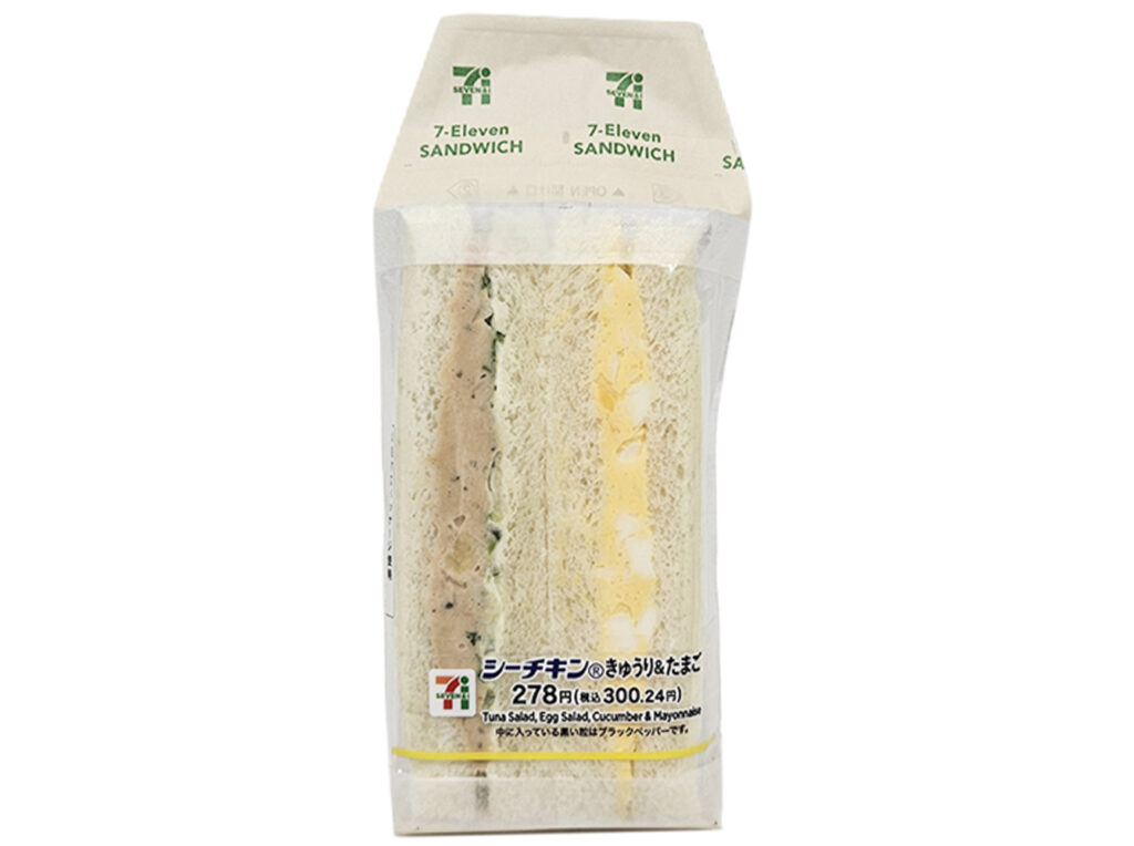 セブンイレブンのシーチキンきゅうり＆たまごサンドを比較する。税込価格：300円、カロリー：353kcal、1円あたりカロリー：1.18kcal/円、たんぱく質：10.7g、1円あたりたんぱく質：0.04g/円、脂質：23.4g、炭水化物：25.6g、糖質：24.1g、食物繊維：1.5g、食塩相当量：1.4g。シーチキンときゅうりの組とたまごの組を合わせたサンドイッチです。アレルギー：卵、乳、小麦。