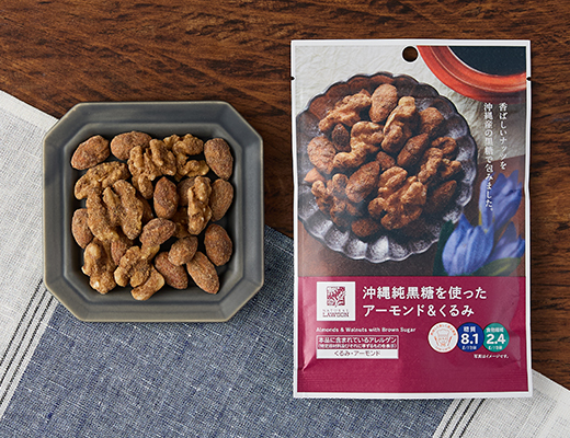 ローソンの沖縄純黒糖を使ったアーモンド＆くるみ。税込価格：228円、カロリー：229kcal、たんぱく質：6.2g、脂質：18.6g、炭水化物：10.5g、糖質：8.1g、食物繊維：2.4g、食塩相当量：0.1g。