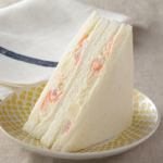 ローソンのポテトサラダサンド。税込価格：297円、カロリー：244kcal、たんぱく質：6.8g、脂質：11.4g、炭水化物：29.7g、糖質：27.6g、食物繊維：2.1g、食塩相当量：1.6g。