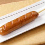 ローソンのジャイアントポークフランク。税込価格：208円、カロリー：290kcal、たんぱく質：8.9g、脂質：24.5g、炭水化物：9g、糖質：7.6g、食物繊維：1.4g、食塩相当量：1.8g。