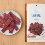 ローソンの牛肉の旨味味わうビーフジャーキーを比較する。税込価格：448円、カロリー：102kcal、1円あたりカロリー：0.23kcal/円、たんぱく質：15.8g、1円あたりたんぱく質：0.04g/円、脂質：1.7g、炭水化物：5.8g、糖質：5.8g、食物繊維：0g、食塩相当量：1.6g。