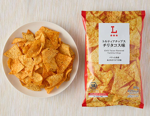 ローソンのトルティアチップス チリタコス味を比較する。税込価格：138円、カロリー：405kcal、1円あたりカロリー：2.93kcal/円、たんぱく質：5.5g、1円あたりたんぱく質：0.04g/円、脂質：21.3g、炭水化物：49.8g、糖質：46g、食物繊維：3.8g、食塩相当量：1.4g。