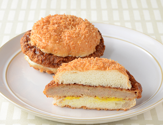 ローソンのはみでるバーガー メンチカツ。税込価格：225円、カロリー：499kcal、たんぱく質：13.3g、脂質：31.5g、炭水化物：41.8g、糖質：39.1g、食物繊維：2.7g、食塩相当量：3.3g。