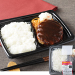 ローソンのボルドー産赤ワイン仕立てのデミソースハンバーグ弁当。税込価格：743円、カロリー：680kcal、たんぱく質：24.8g、脂質：22.8g、炭水化物：97.6g、糖質：90.4g、食物繊維：7.2g、食塩相当量：3.9g。