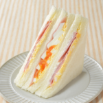 ローソンのハムたまごサンド。税込価格：383円、カロリー：327kcal、たんぱく質：11.7g、脂質：18.2g、炭水化物：29.8g、糖質：28.4g、食物繊維：1.4g、食塩相当量：2.3g。