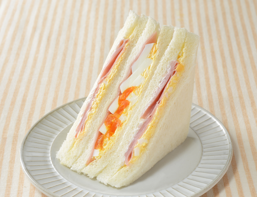 ローソンのハムたまごサンド。税込価格：383円、カロリー：327kcal、たんぱく質：11.7g、脂質：18.2g、炭水化物：29.8g、糖質：28.4g、食物繊維：1.4g、食塩相当量：2.3g。
