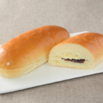 ローソンのバター香るコッペ 粒あん＆マーガリン。税込価格：160円、カロリー：387kcal、たんぱく質：8g、脂質：17.2g、炭水化物：51.3g、糖質：48.8g、食物繊維：2.5g、食塩相当量：0.7g。