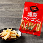 亀田製菓　ザクスティック　燻製炙りベーコン風味 ローソン 時間を惜しまず低温でじっくり揚げることで実現した噛めば噛むほど広がる薫りと余韻が愉しめる味わい。