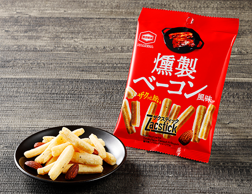 亀田製菓　ザクスティック　燻製炙りベーコン風味 ローソン 時間を惜しまず低温でじっくり揚げることで実現した噛めば噛むほど広がる薫りと余韻が愉しめる味わい。