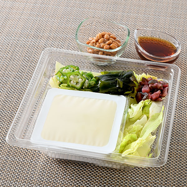ファミリーマートのまるごと豆腐と納豆のネバネバサラダを比較する。税込価格：438円、カロリー：147kcal、1円あたりカロリー：0.34kcal/円、たんぱく質：12.5g、1円あたりたんぱく質：0.03g/円、脂質：7.2g、炭水化物：9.4g、食塩相当量：2.2g。豆腐がまるごと入ったサラダです。レタス、大根にオクラ、わかめ、しば漬けを合わせました。納豆小袋とポン酢ドレッシング付きです。アレルギー：小麦、卵、大豆、鶏肉、豚肉、りんご。