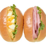 セブンイレブンのミニロールたまごサラダ＆ハムを比較する。税込価格：279円、カロリー：296kcal、たんぱく質：9g、脂質：15.6g、炭水化物：30.7g、糖質：29g、食物繊維：1.7g、食塩相当量：1.2g。定番具材のたまごとハムの２種類の味が楽しめる、手軽に持ち運びしやすいボックスタイプのロールです。アレルギー：卵、乳、小麦。