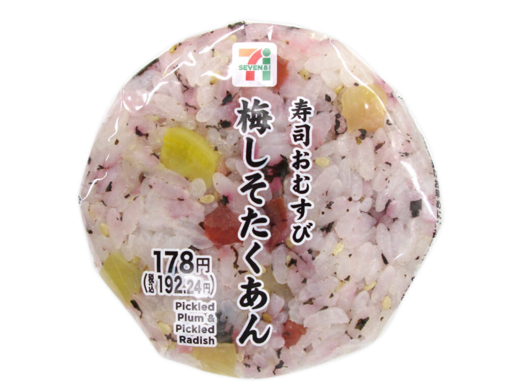 セブンイレブンの寿司おむすび梅しそたくあんを比較する。税込価格：192円、カロリー：185kcal、1円あたりカロリー：0.96kcal/円、たんぱく質：2.8g、1円あたりたんぱく質：0.01g/円、脂質：1g、炭水化物：42.1g、糖質：40.2g、食物繊維：1.9g、食塩相当量：2.5g。カリカリ梅とたくあんを混ぜ込んだ、彩りと食感を楽しめる寿司おむすびです。アレルギー：なし。