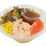 セブンイレブンの蒸し鶏と彩り野菜のラーメンサラダを比較する。税込価格：365円、カロリー：332kcal、1円あたりカロリー：0.91kcal/円、たんぱく質：13.8g、1円あたりたんぱく質：0.04g/円、脂質：5.4g、炭水化物：58.9g、糖質：55g、食物繊維：3.9g、食塩相当量：2.2g。蒸し鶏と彩り野菜に和風玉葱ドレッシングをかけて食べるラーメンサラダです。アレルギー：卵、乳、小麦。