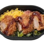 セブンイレブンのソースひれかつ弁当（麦飯）を比較する。税込価格：464円、カロリー：473kcal、たんぱく質：16.1g、脂質：16.6g、炭水化物：67.2g、糖質：62.3g、食物繊維：4.9g、食塩相当量：2g。ひれかつと錦糸玉子，小松菜の炒め煮，漬物を彩り良く盛り付けたミニサイズのお弁当です。アレルギー：卵、小麦。
