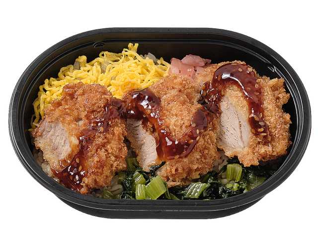 セブンイレブンのソースひれかつ弁当（麦飯）を比較する。税込価格：464円、カロリー：473kcal、たんぱく質：16.1g、脂質：16.6g、炭水化物：67.2g、糖質：62.3g、食物繊維：4.9g、食塩相当量：2g。ひれかつと錦糸玉子，小松菜の炒め煮，漬物を彩り良く盛り付けたミニサイズのお弁当です。アレルギー：卵、小麦。