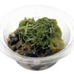 セブンイレブンのなす炒り 古川なす使用を比較する。税込価格：322円、カロリー：113kcal、たんぱく質：6.8g、脂質：4.4g、炭水化物：12.9g、糖質：10.3g、食物繊維：2.6g、食塩相当量：1.6g。古川なすとピーマンを味噌で炒めた、甘じょっぱい味付けのカップデリです。アレルギー：小麦。