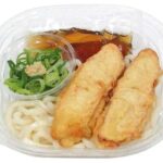 セブンイレブンの冷しとり天ぶっかけうどんを比較する。税込価格：605円、カロリー：559kcal、1円あたりカロリー：0.92kcal/円、たんぱく質：21g、1円あたりたんぱく質：0.03g/円、脂質：12.9g、炭水化物：91.3g、糖質：88g、食物繊維：3.3g、食塩相当量：4.9g。ボリューム感のあるとり天２本を盛り付けた冷しぶっかけうどんです。アレルギー：卵、乳、小麦。
