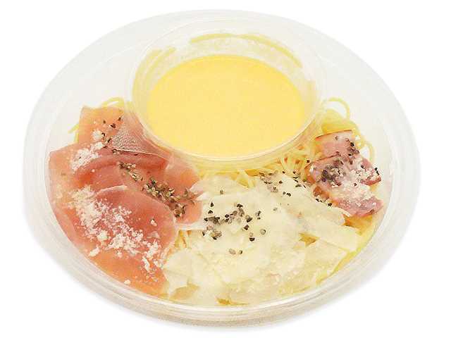 セブンイレブンの冷製パスタ カルボナーラ 生ハムとベーコンを比較する。税込価格：562円、カロリー：434kcal、1円あたりカロリー：0.77kcal/円、たんぱく質：18.5g、1円あたりたんぱく質：0.03g/円、脂質：16g、炭水化物：55.6g、糖質：52.5g、食物繊維：3.1g、食塩相当量：3.6g。たまごとチーズのコクを味わえるカルボナーラソースに、生ハムとベーコンを盛り付けた冷製パスタです。アレルギー：卵、乳、小麦。