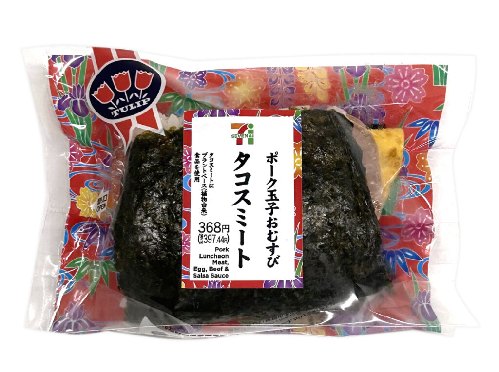 セブンイレブンのポーク玉子おむすび タコスミートを比較する。税込価格：397円、カロリー：429kcal、たんぱく質：13.6g、脂質：19.9g、炭水化物：50.3g、糖質：47.3g、食物繊維：3g、食塩相当量：2.1g。スパイシーなチリミートと少し辛味のあるタコソース、まろやかなチーズソースをポーク玉子おむすびに挟んだ商品です。アレルギー：卵、乳、小麦。