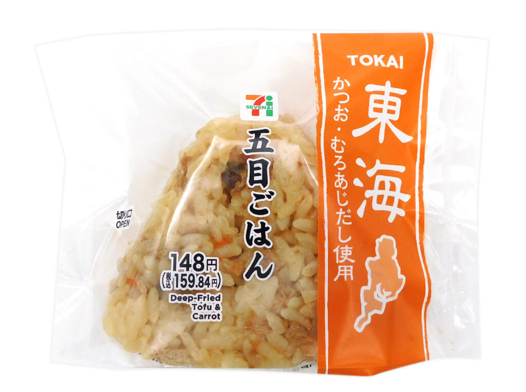 セブンイレブンの東海限定 五目ごはんおむすびを比較する。税込価格：160円、カロリー：188kcal、1円あたりカロリー：1.18kcal/円、たんぱく質：4.7g、1円あたりたんぱく質：0.03g/円、脂質：1.7g、炭水化物：39.5g、糖質：37.4g、食物繊維：2.1g、食塩相当量：1.8g。かつおだし・むろあじだしを使用した、地区に馴染みのある味付けに仕立てた風味豊かな五目ごはんのおむすびです。アレルギー：小麦。