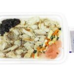 セブンイレブンの真あじ一夜干し御飯（もち麦）を比較する。税込価格：464円、カロリー：282kcal、たんぱく質：14g、脂質：1.6g、炭水化物：54.7g、糖質：50.9g、食物繊維：3.8g、食塩相当量：2.6g。旨味のある真あじ一夜干しのほぐし身を盛付けた御飯です。アレルギー：小麦。