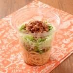 ローソンの振っておいしいパスタサラダ ピリ辛まぜそば風を比較する。税込価格：397円、カロリー：207kcal、1円あたりカロリー：0.52kcal/円、たんぱく質：11.3g、1円あたりたんぱく質：0.03g/円、脂質：6.1g、炭水化物：28.2g、糖質：25g、食物繊維：3.2g、食塩相当量：3.4g。サイコロチャーシューをトッピングしたピリ辛まぜそば風パスタサラダ。アレルギー：小麦、卵、乳成分、ごま、さば、大豆、鶏肉、豚肉。