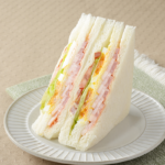 ローソンの盛りすぎ！BLTEサンドを比較する。税込価格：430円、カロリー：266kcal、1円あたりカロリー：0.62kcal/円、たんぱく質：13.2g、1円あたりたんぱく質：0.03g/円、脂質：12.3g、炭水化物：26.4g、糖質：24.8g、食物繊維：1.6g、食塩相当量：2g。ベーコンが51％増量！ベーコン、レタス、トマト、たまごと4種類の具材を楽しめるサンドイッチです。見た目にも味わいにもボリューム感、満足感のある仕立てです。アレルギー：小麦、卵、乳成分、大豆、豚肉、りんご、ゼラチン。