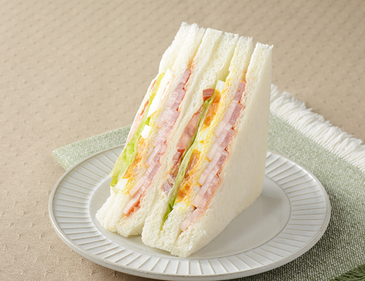 ローソンの盛りすぎ！BLTEサンドを比較する。税込価格：430円、カロリー：266kcal、1円あたりカロリー：0.62kcal/円、たんぱく質：13.2g、1円あたりたんぱく質：0.03g/円、脂質：12.3g、炭水化物：26.4g、糖質：24.8g、食物繊維：1.6g、食塩相当量：2g。ベーコンが51％増量！ベーコン、レタス、トマト、たまごと4種類の具材を楽しめるサンドイッチです。見た目にも味わいにもボリューム感、満足感のある仕立てです。アレルギー：小麦、卵、乳成分、大豆、豚肉、りんご、ゼラチン。