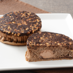 ローソンのザクっと焼きチョコパンを比較する。税込価格：192円、カロリー：338kcal、たんぱく質：6.9g、脂質：12.7g、炭水化物：50.8g、糖質：47.2g、食物繊維：3.6g、食塩相当量：0.3g。チョコチップとローストアーモンドのザクっと食感が楽しめるチョコパン。アレルギー：小麦、卵、乳成分、アーモンド、大豆。