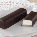 ローソンのご褒美スティックケーキ とろける生マシュマロを比較する。税込価格：362円、カロリー：221kcal、たんぱく質：3.4g、脂質：14.5g、炭水化物：19.9g、糖質：18.7g、食物繊維：1.2g、食塩相当量：0.1g。パリッとチョコととろふわ食感の生マシュマロを楽しむスティックスイーツ。アレルギー：小麦、卵、乳成分、大豆、ゼラチン。